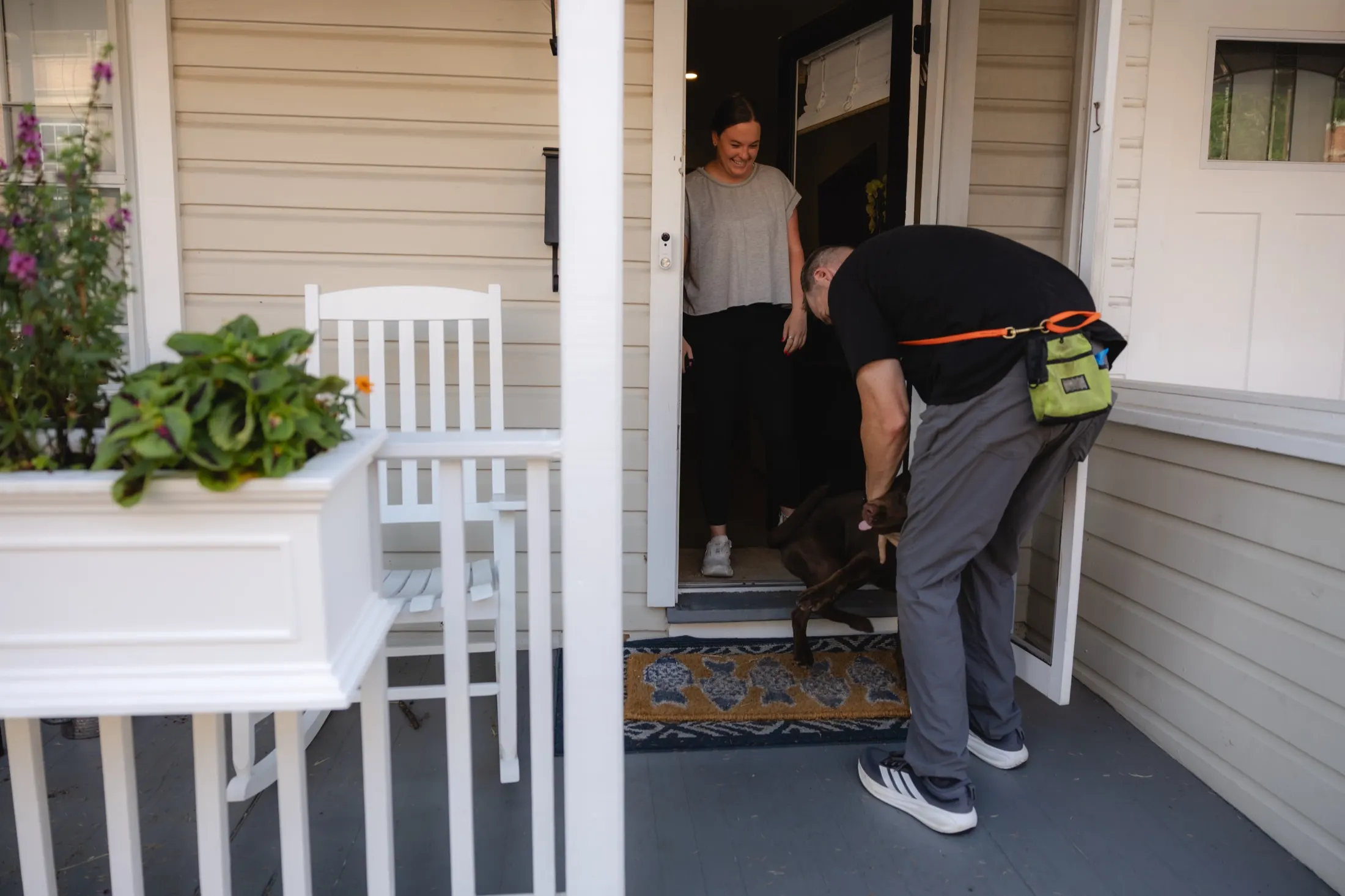Zak greeting a chocolate lab at the front door at the start of a session